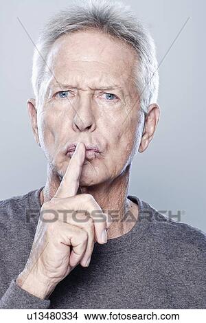 Portrait of senior man with finger on his lips, studio shot View Large Photo Image Picture - Portrait of senior man with finger on his lips, studio shot. Fotosearch