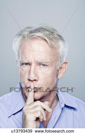 Portrait of senior man with finger on lips, studio shot View Large Photo Image Stock Photo - Portrait of senior man with finger on lips, studio shot. Fotosearch