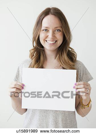 Portrait of serene young woman holding blank card View Large Photo Image Stock Photo - Portrait of serene young woman holding blank card. Fotosearch