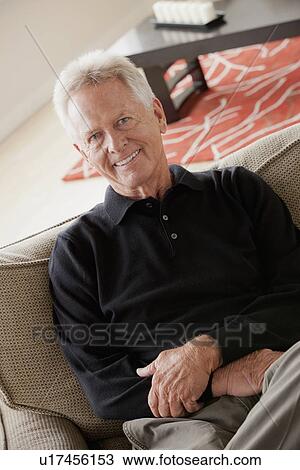 Portrait of smiling senior man sitting on sofa View Large Photo Image Stock Image - Portrait of smiling senior man sitting on sofa. Fotosearch