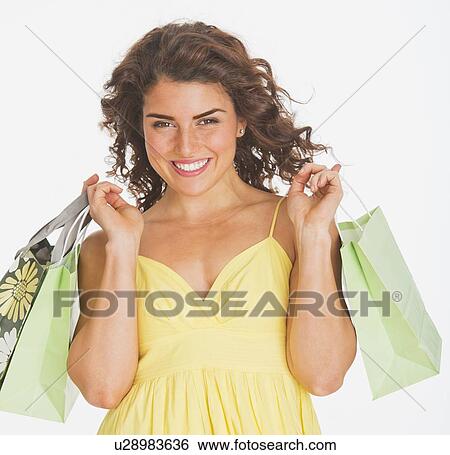 Portrait of smiling woman carrying shopping bags, studio shot View Large Photo Image Stock Photograph - Portrait of smiling woman carrying shopping bags, studio shot. Fotosearch