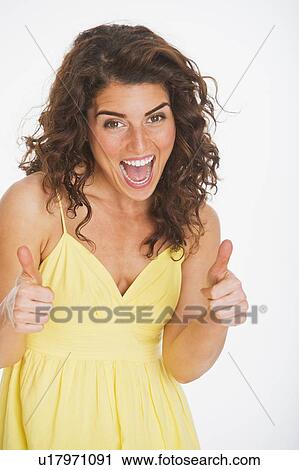 Stock Image - Portrait of smiling woman gesturing, studio shot. Fotosearch