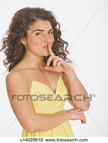 Stock Photo - Portrait of smiling woman gesturing, studio shot. Fotosearch