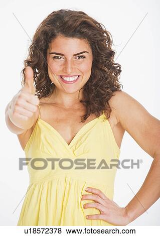 Stock Photo - Portrait of smiling woman gesturing, studio shot. Fotosearch
