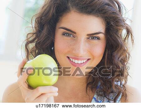Portrait of smiling woman holding apple View Large Photo Image Stock Photo - Portrait of smiling woman holding apple. Fotosearch