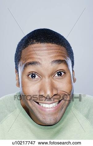 Portrait of smiling young man, studio shot View Large Photo Image Stock Photo - Portrait of smiling young man, studio shot. Fotosearch