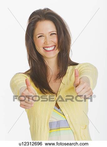 Portrait of smiling young woman showing thumbs up, studio shot View Large Photo Image Stock Photograph - Portrait of smiling young woman showing thumbs up, studio shot. Fotosearch