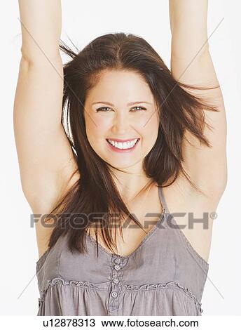 Portrait of smiling young woman with arms up, studio shot View Large Photo Image Stock Image - Portrait of smiling young woman with arms up, studio shot. Fotosearch