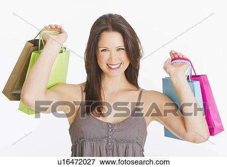 Portrait of smiling young woman with shopping bags, studio shot View Large Photo Image Stock Photo - Portrait of smiling young woman with shopping bags, studio shot. Fotosearch