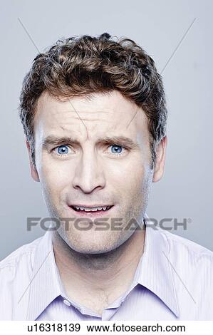Stock Photo - Portrait of surprised mid adult man, studio shot. Fotosearch