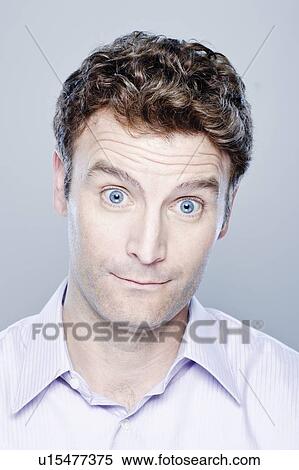 Stock Photography - Portrait of surprised mid adult man, studio shot. Fotosearch