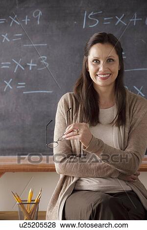 Portrait of teacher in classroom holding glasses View Large Photo Image Stock Photo - Portrait of teacher in classroom holding glasses. Fotosearch