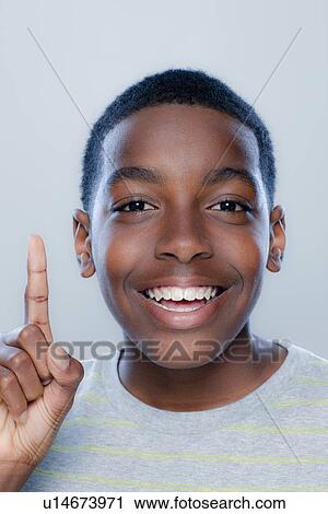 Stock Image - Portrait of teenage boy (14-15), studio shot. Fotosearch