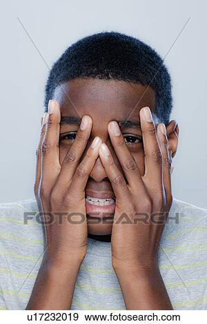 Stock Photo - Portrait of teenage boy (14-15), studio shot. Fotosearch