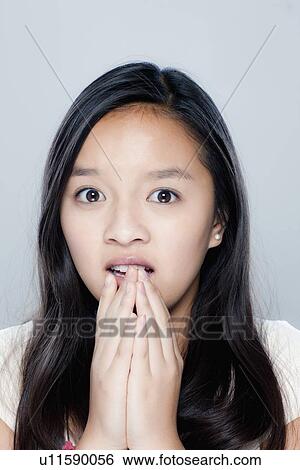 Stock Photograph - Portrait of teenage girl (14-15), studio shot. Fotosearch