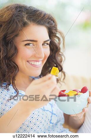 Portrait of woman eating fruit salad View Large Photo Image Picture - Portrait of woman eating fruit salad. Fotosearch