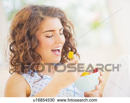 Portrait of woman eating fruit salad View Large Photo Image Stock Image - Portrait of woman eating fruit salad. Fotosearch