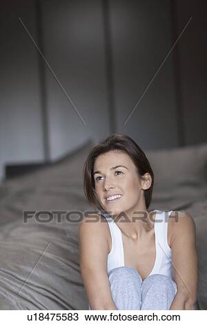 Stock Image - Portrait of woman in bedroom. Fotosearch