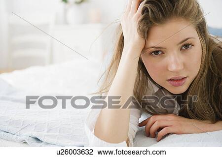 Portrait of woman lying on bed View Large Photo Image Stock Image - Portrait of woman lying on bed. Fotosearch