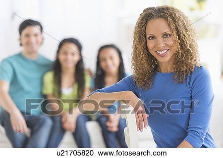 Stock Image - Portrait of woman with husband and daughters (10-13) in background. Fotosearch