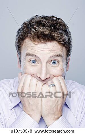 Stock Photo - Portrait of worried mid adult man, studio shot. Fotosearch