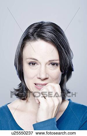 Stock Photo - Portrait of worried mid adult woman, studio shot. Fotosearch