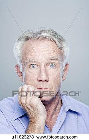 Stock Photo - Portrait of worried senior man, studio shot. Fotosearch