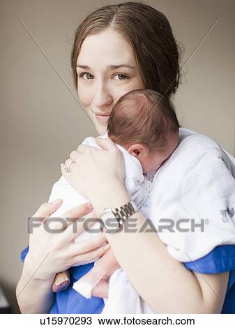 Portrait of young female nurse holding baby boy (2-5 months) View Large Photo Image Stock Image - Portrait of young female nurse holding baby boy (2-5 months). Fotosearch