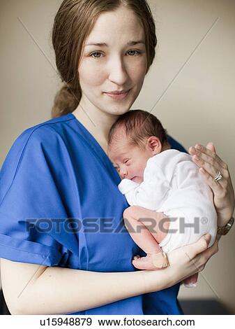 Portrait of young female nurse holding baby boy (2-5 months) View Large Photo Image Stock Photo - Portrait of young female nurse holding baby boy (2-5 months). Fotosearch