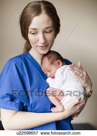 Portrait of young female nurse holding baby boy (2-5 months) View Large Photo Image Stock Photo - Portrait of young female nurse holding baby boy (2-5 months). Fotosearch