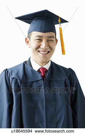 Picture - Portrait of young man in graduation gown, studio shot. Fotosearch