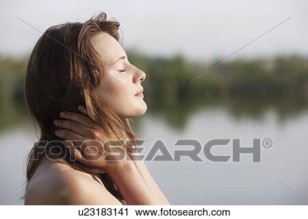 Portrait of young woman against lake View Large Photo Image Stock Image - Portrait of young woman against lake. Fotosearch