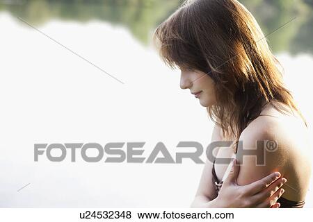 Portrait of young woman against lake View Large Photo Image Stock Photo - Portrait of young woman against lake. Fotosearch