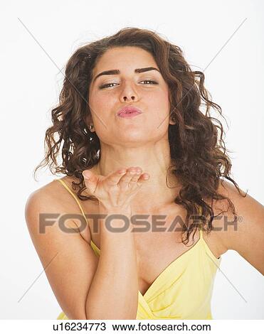 Portrait of young woman blowing kiss, studio shot View Large Photo Image Stock Image - Portrait of young woman blowing kiss, studio shot. Fotosearch