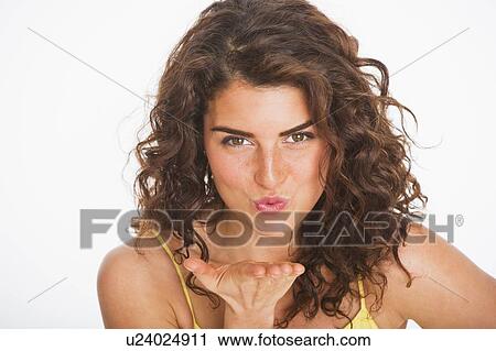 Portrait of young woman blowing kiss, studio shot View Large Photo Image Stock Image - Portrait of young woman blowing kiss, studio shot. Fotosearch