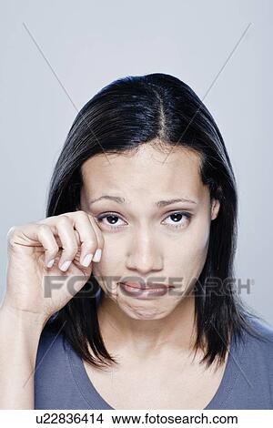 Picture - Portrait of young woman crying, studio shot. Fotosearch