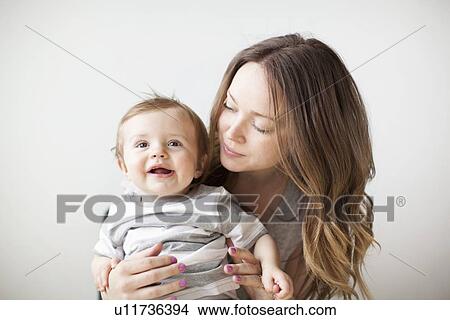 Picture - Portrait of young woman embracing baby boy (6-11 months). Fotosearch