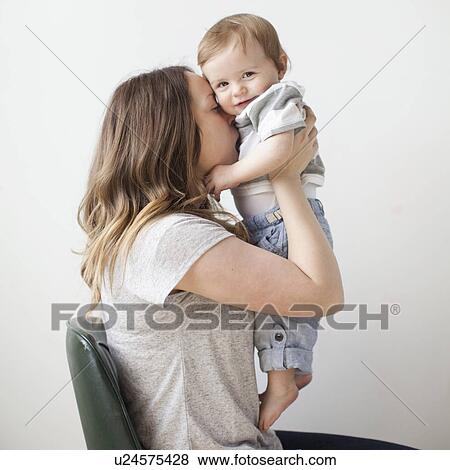 Portrait of young woman embracing baby boy (6-11 months) View Large Photo Image Stock Photo - Portrait of young woman embracing baby boy (6-11 months). Fotosearch