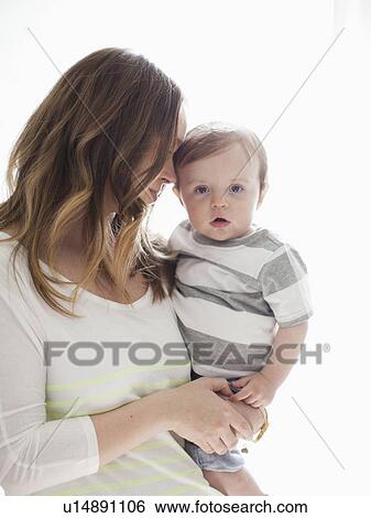 Stock Photograph - Portrait of young woman embracing baby boy (6-11 months). Fotosearch