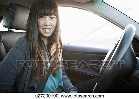 Portrait of young woman in car View Large Photo Image Stock Image - Portrait of young woman in car. Fotosearch