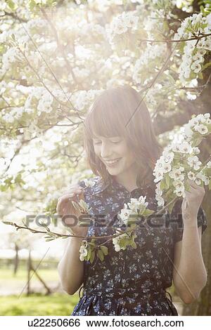 Stock Photograph - Portrait of young woman in spring orchard. Fotosearch