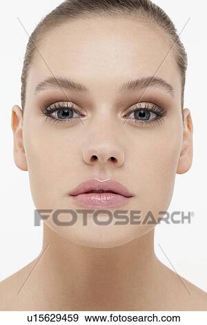 Stock Photo - Portrait of young woman looking straight at camera. Fotosearch