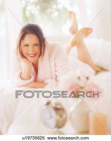 Portrait of young woman lying on bed View Large Photo Image Stock Photography - Portrait of young woman lying on bed. Fotosearch