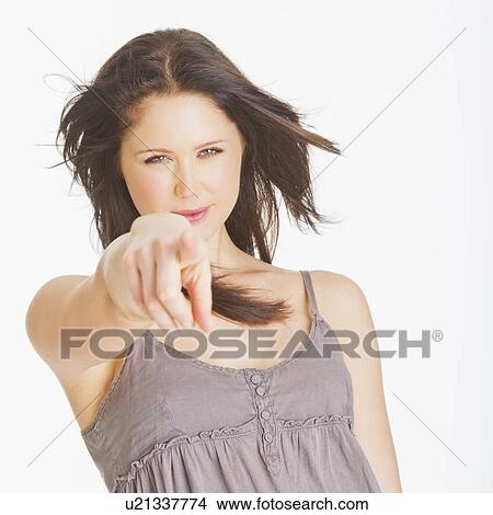 Portrait of young woman pointing with finger, studio shot View Large Photo Image Picture - Portrait of young woman pointing with finger, studio shot. Fotosearch