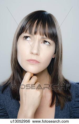 Stock Photograph - Portrait of young woman, studio shot. Fotosearch