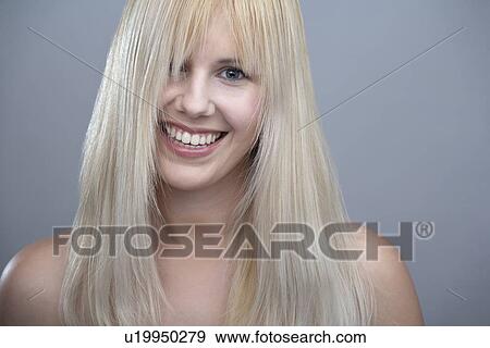 Stock Photo - Portrait of young woman with blonde hair, studio shot. Fotosearch