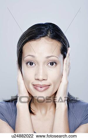 Portrait of young woman with hands covering ears, studio shot View Large Photo Image Stock Image - Portrait of young woman with hands covering ears, studio shot. Fotosearch