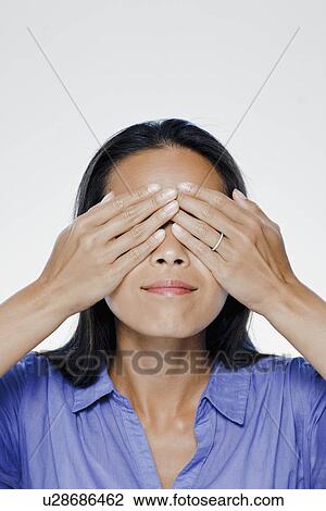 Portrait of young woman with hands covering eyes, studio shot View Large Photo Image Stock Image - Portrait of young woman with hands covering eyes, studio shot. Fotosearch