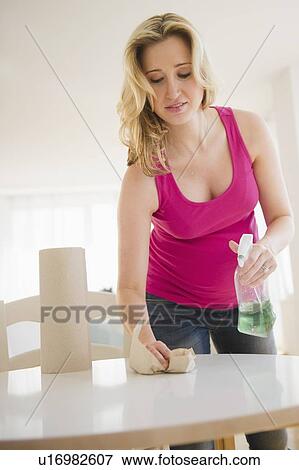 Pregnant woman cleaning table View Large Photo Image Stock Photo - Pregnant woman cleaning table. Fotosearch