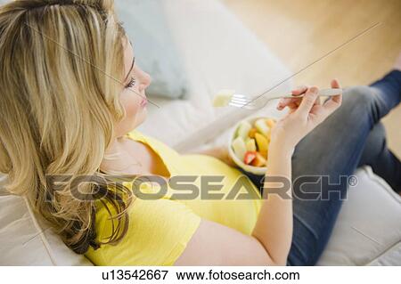 Pregnant woman eating fruit salad View Large Photo Image Stock Photo - Pregnant woman eating fruit salad. Fotosearch